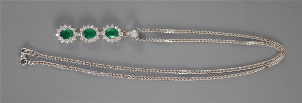 A modern 18ct white gold, emerald and diamond set oval triple cluster drop pendant, on an 18ct white gold chain,